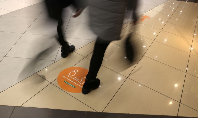 Sign reading “Please keep distance” is seen on the floor