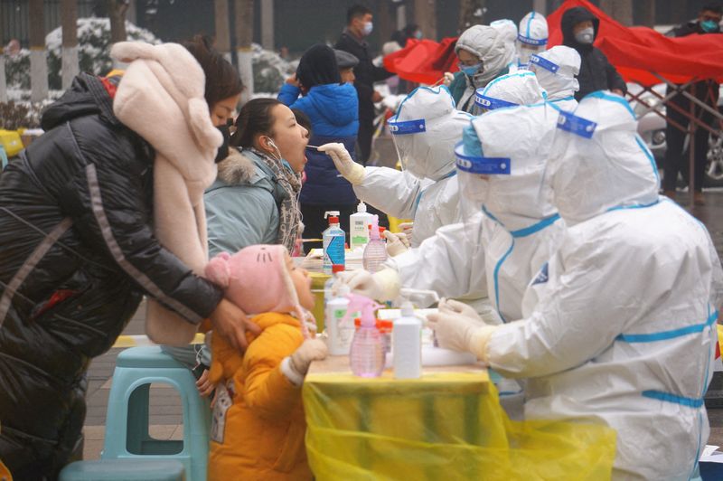 Medical workers collect swabs from residents during a citywide nucleic
