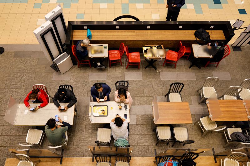 People dine at tables with partition boards inside a restaurant
