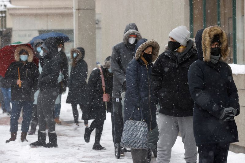 FILE PHOTO: People wait in falling snow for COVID-19 test