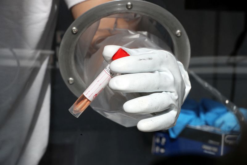 Man holds a swab sample as he demonstrates operating of