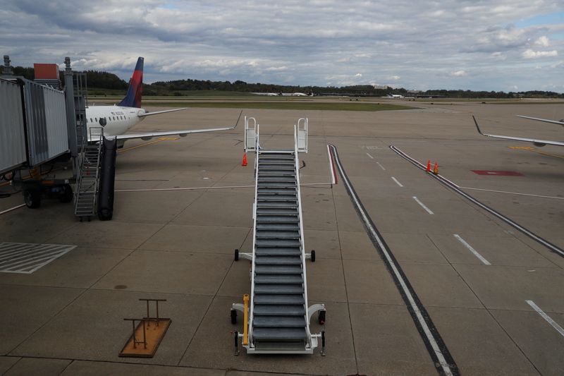 Stairs stand on a tarmac next to a Delta Air