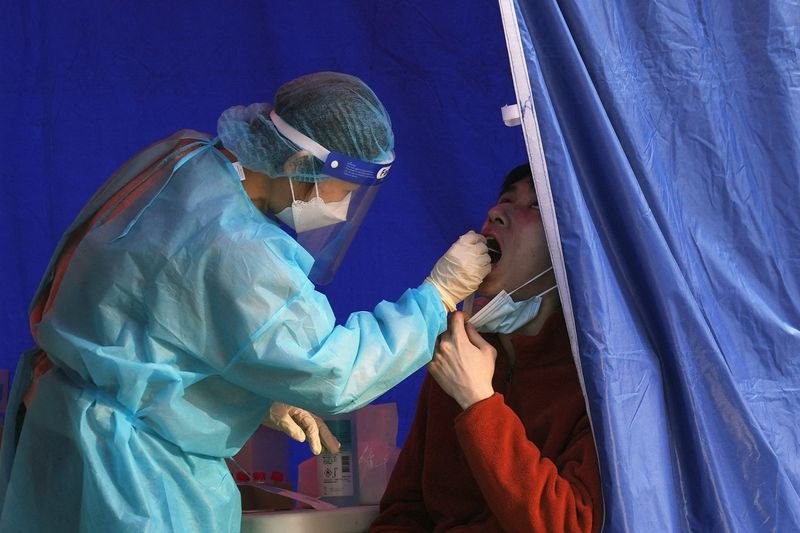 Health worker collects a swab sample from a man at