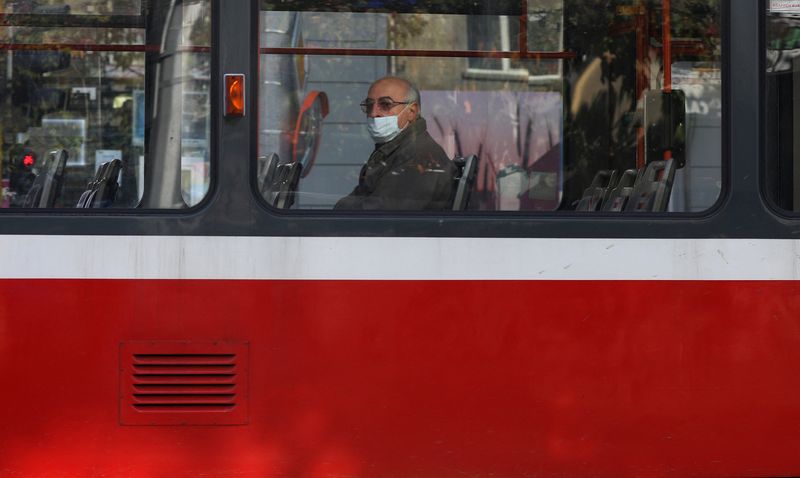 Man wearing protective face mask rides on a train in
