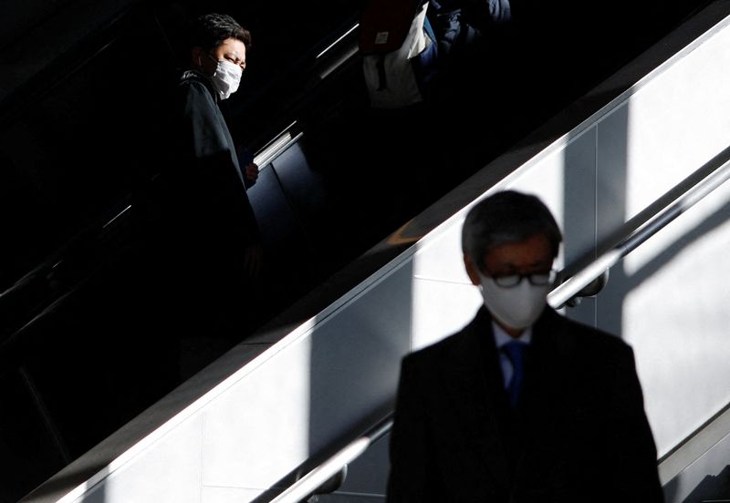 Passengers wearing protective face masks are pictured at a train