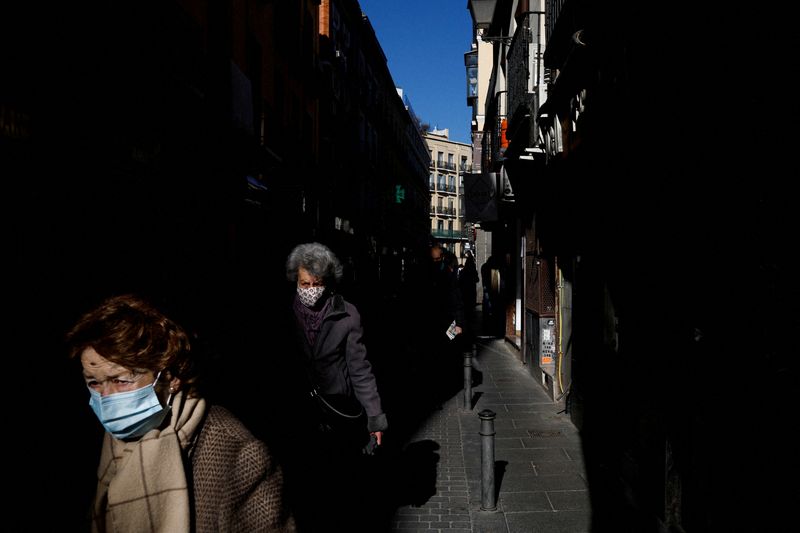 FILE PHOTO: Elderly women wearing face masks walk along a