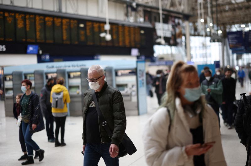 People walk at the Waterloo train station amid the coronavirus