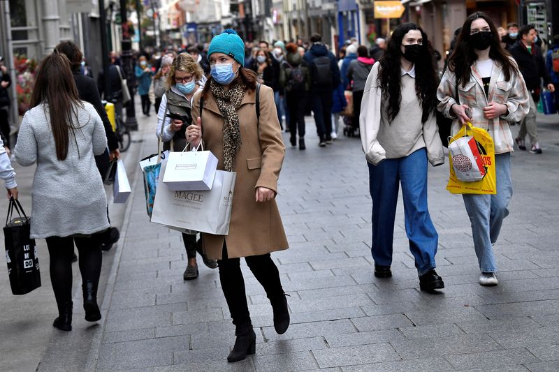 FILE PHOTO: People wear protective face masks while out for