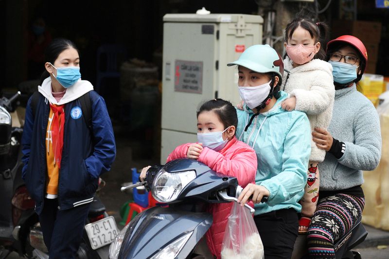 FILE PHOTO: A family wears protective masks as they ride