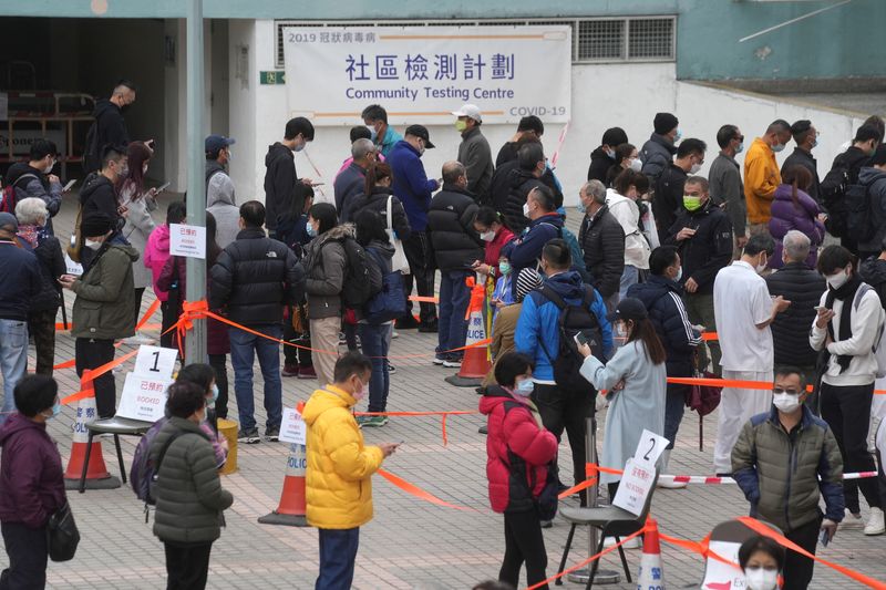 People wearing face masks queue at a community nucleic acid