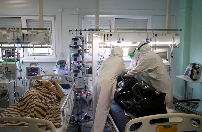 FILE PHOTO: Medical specialists place the body of a person