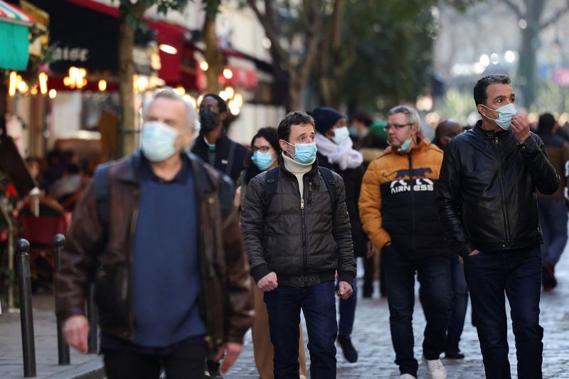 People wearing protective face masks walk in a street in