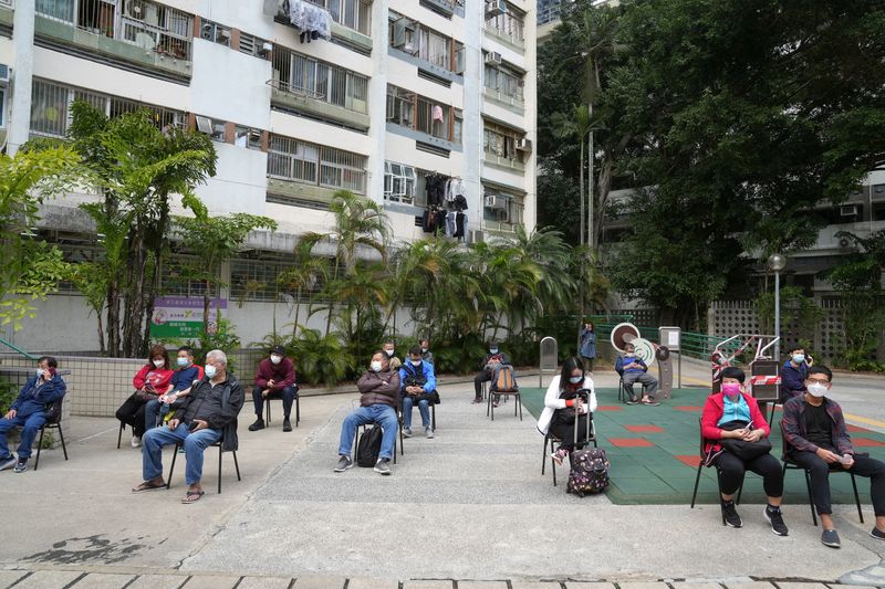 FILE PHOTO: People wait for their swab samples to be