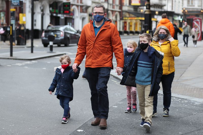 People wearing masks walk in London