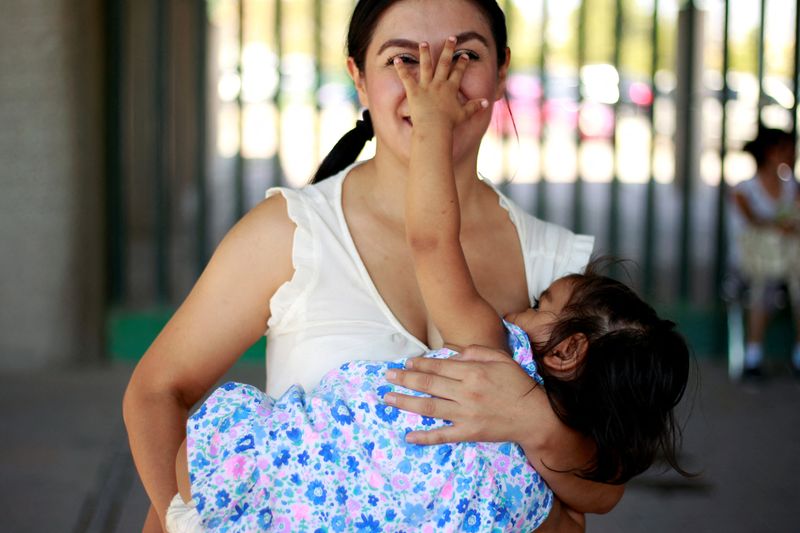 FILE PHOTO: A mother reacts as she nurses her child
