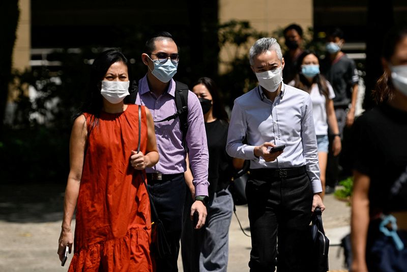 People wearing face masks cross a road, amid the coronavirus