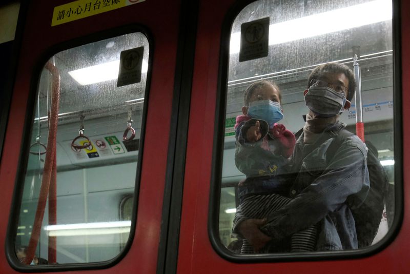 FILE PHOTO: Passengers wear face masks in a Hong Kong