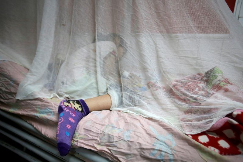 FILE PHOTO: A girl with dengue fever receives attention at