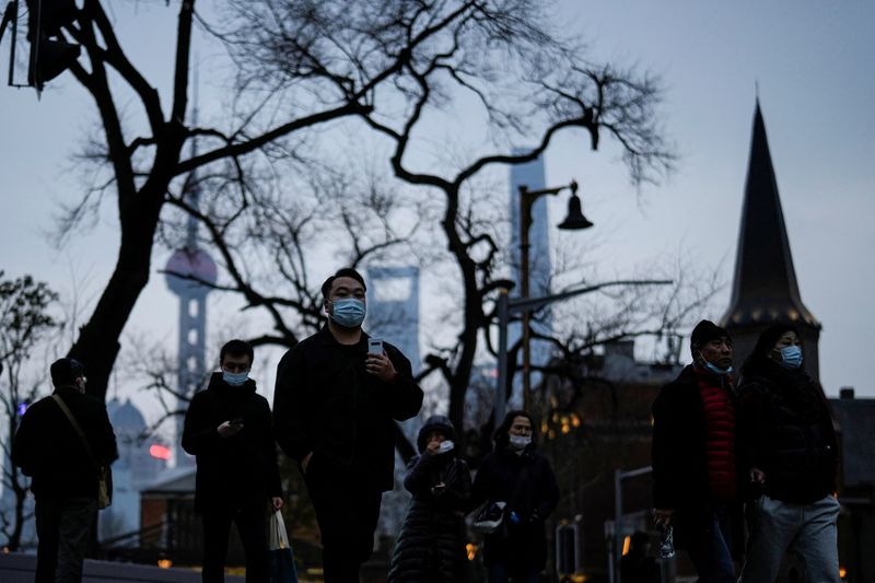 People wearing protective masks walk on street, following new coronavirus