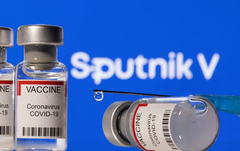 Illustration shows vials labelled “VACCINE Coronavirus COVID-19” and a syringe
