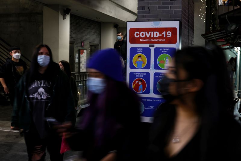 People walk with protective face masks, amid the coronavirus disease