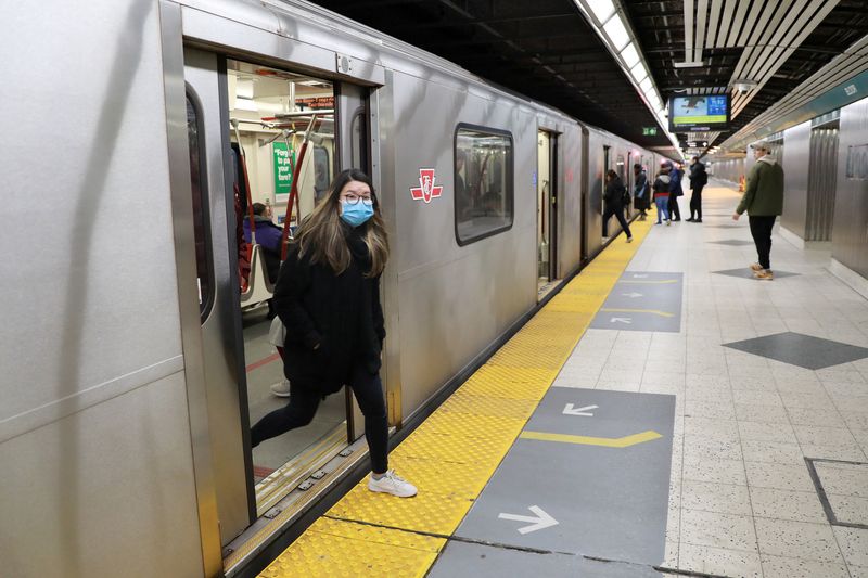 FILE PHOTO: A woman wearing a mask exits a subway