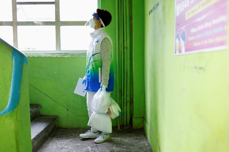 A volunteer holds anti-epidemic bags as she delivers them to