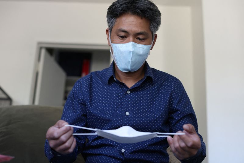 LA-based freight forwarder Tony Chen checks a kid-sized KF94 mask