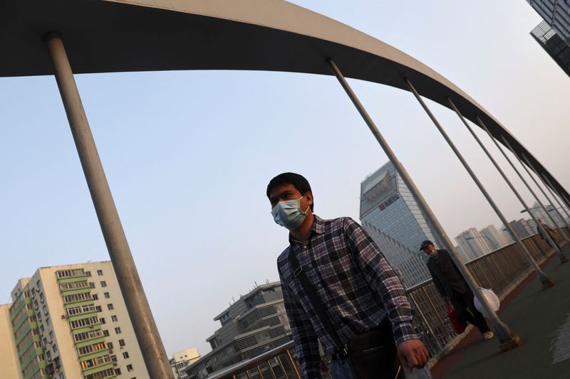 Man wearing a face mask walks on an overpass, following