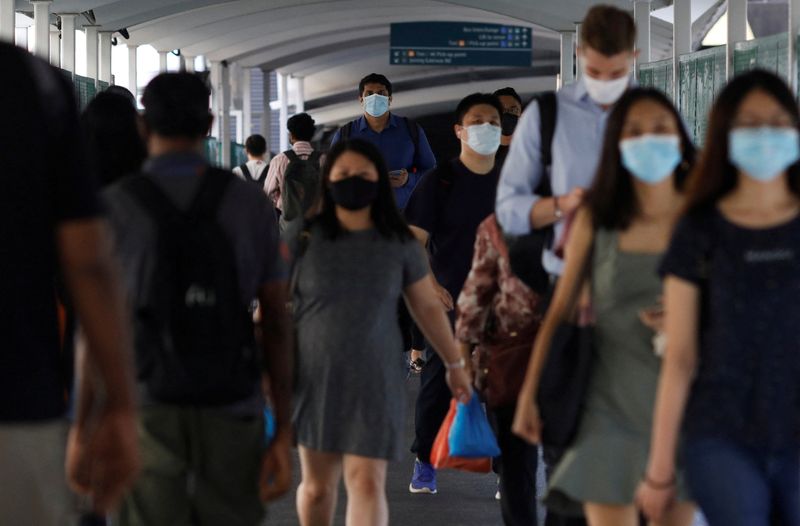FILE PHOTO: Commuters leave a train station during the coronavirus