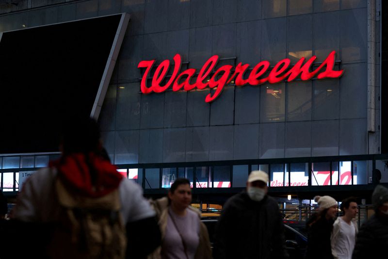 FILE PHOTO: People walk by a Walgreens, owned by the