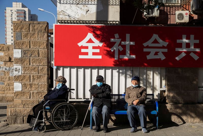 FILE PHOTO: Elderly people sit in a street during morning
