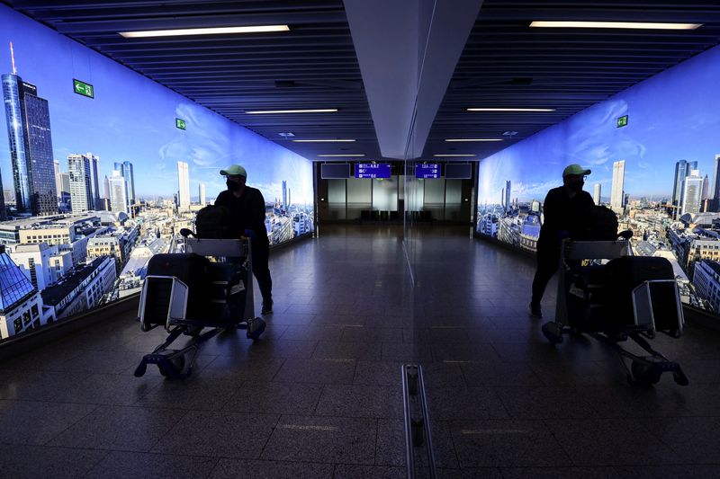 FILE PHOTO: A man pushes a cart through Frankfurt airport,