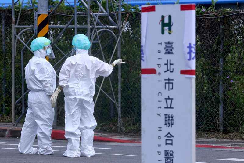 FILE PHOTO: Medical workers in full PPE talk to each