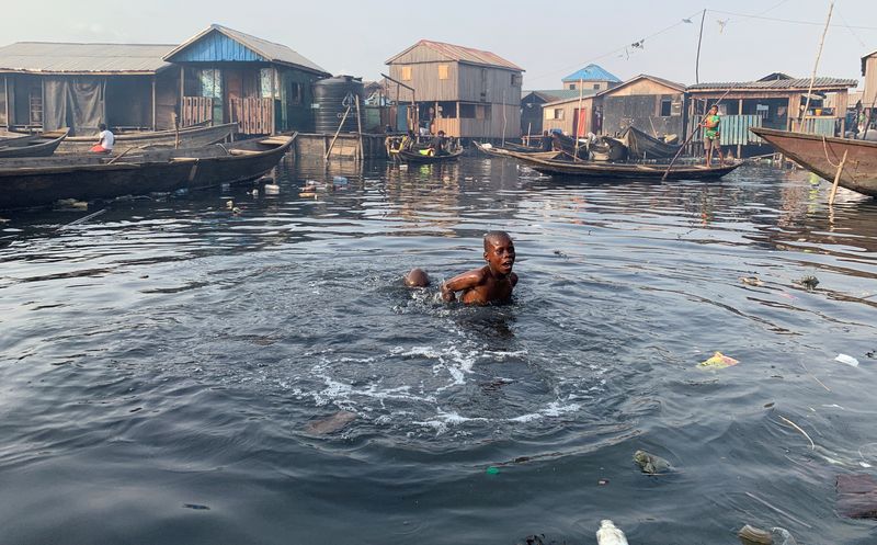 FILE PHOTO: A boy swims in the polluted water of