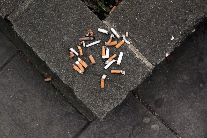 FILE PHOTO: Cigarette butt ends are seen discarded on a