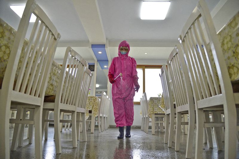A worker disinfects a dining room at a sanitary supplies