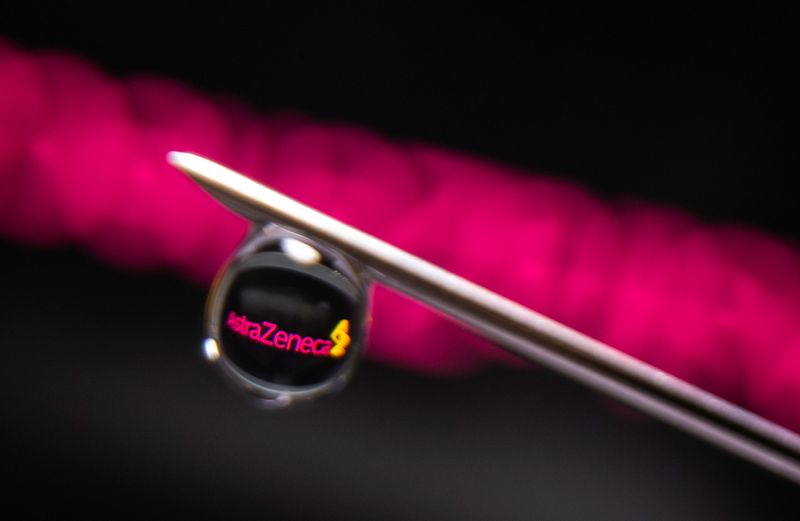 AstraZeneca logo is reflected in a drop on a syringe