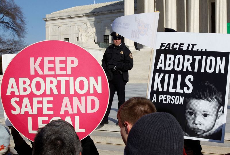 FILE PHOTO: A police officer watches pro-life and pro-choice supporters