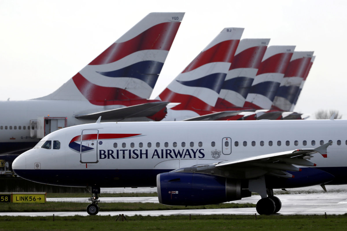 FILE PHOTO: BA plane taxis past tail fins of parked