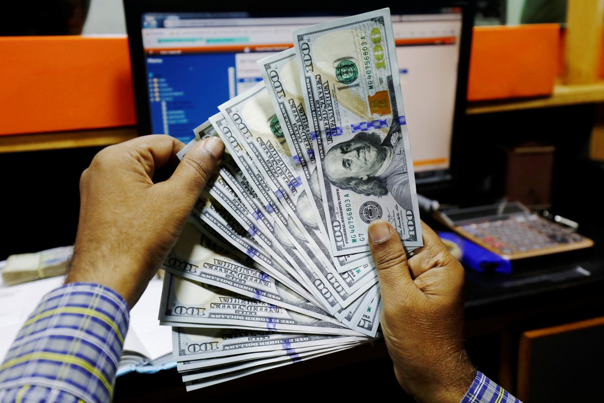A trader shows U.S. dollar notes at a currency exchange