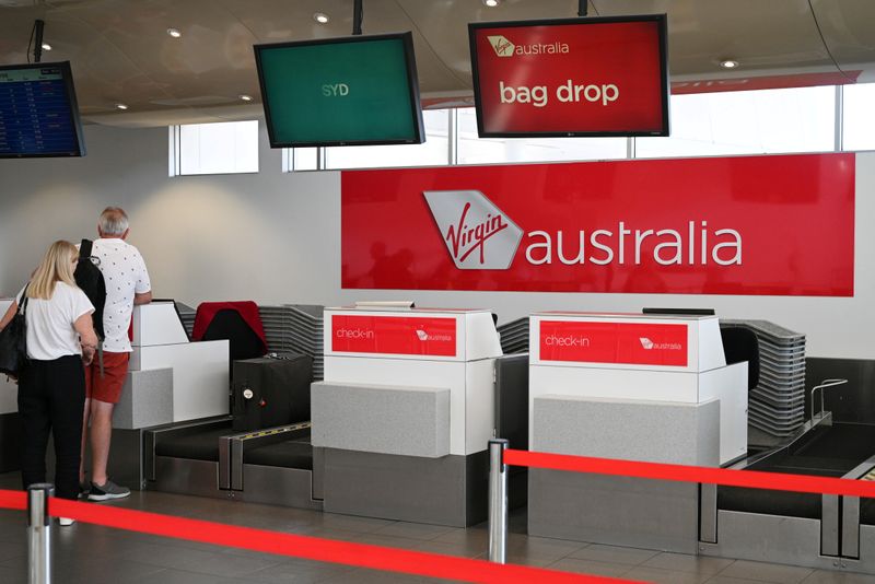 FILE PHOTO:  Travelers stand at a Virgin Australia Airlines