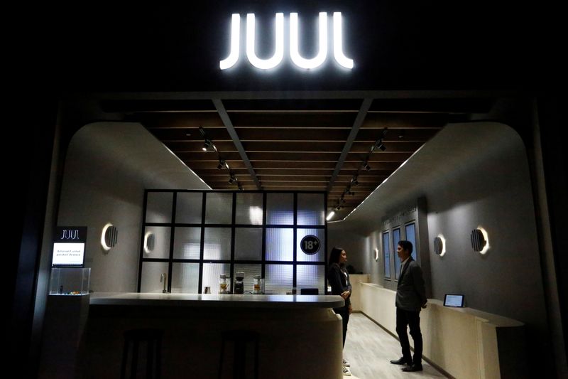 Shopkeepers stand inside a Juul shop at a shopping mall