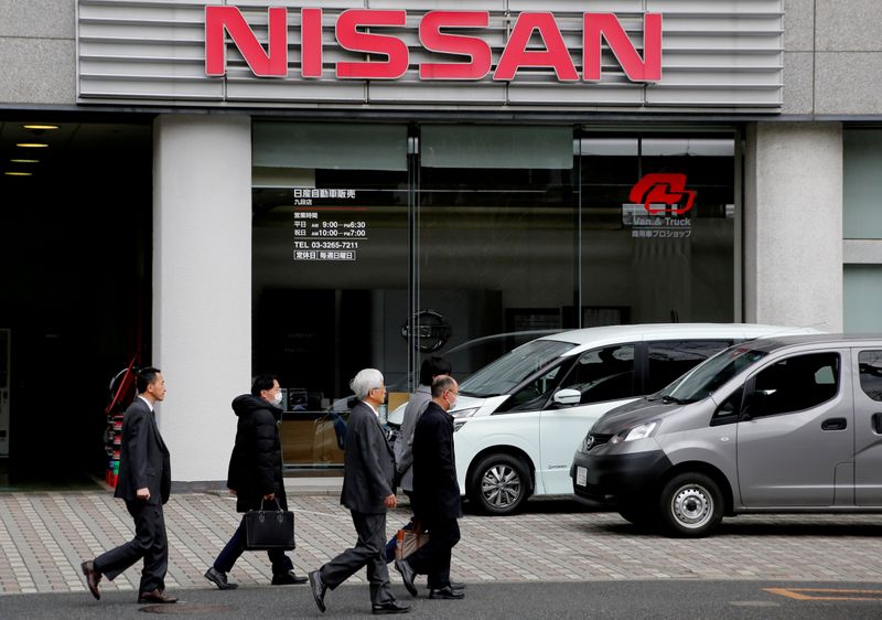 FILE PHOTO: People walk past a dealer shop of Nissan