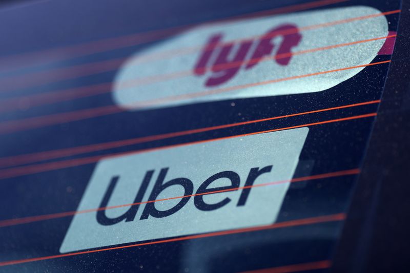 Uber and Lyft signs are seen on a car in