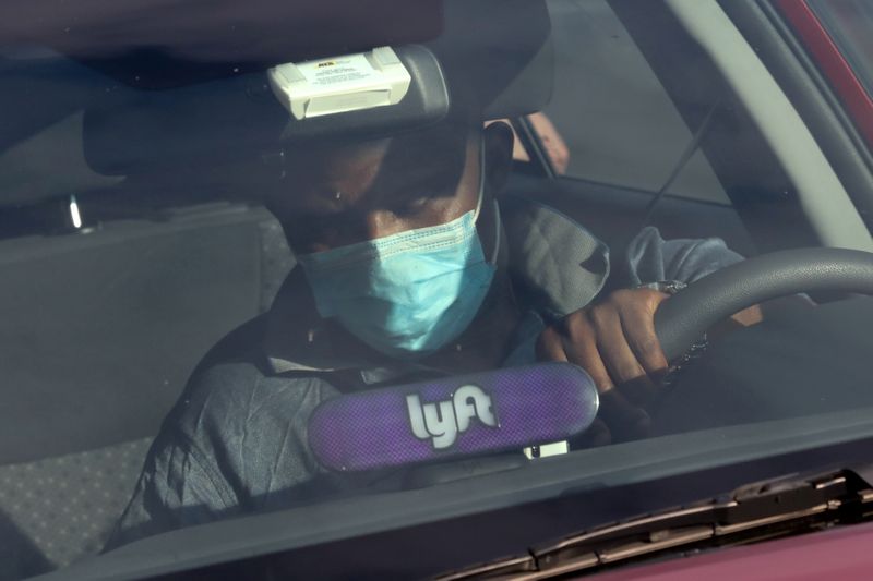 FILE PHOTO: A Lyft rideshare driver wears a mask as