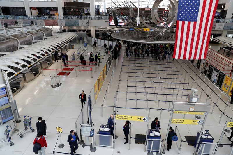 FILE PHOTO: Passengers walk through Terminal 1, after further cases