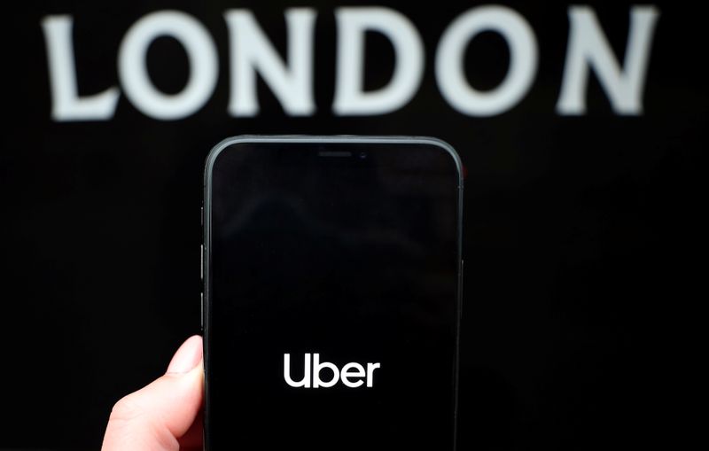 The Uber logo is displayed on a mobile phone in