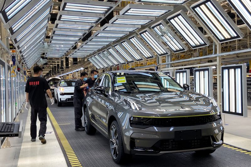 Employees wearing face masks work on a Lynk &Co car