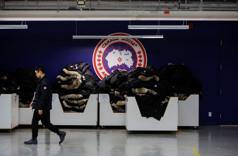 A man walks by jackets at the Canada Goose factory